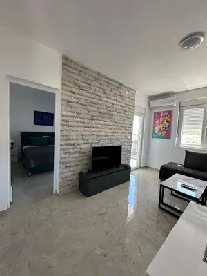 a living room with a brick fireplace with a couch at D&D I apartments in Sutomore