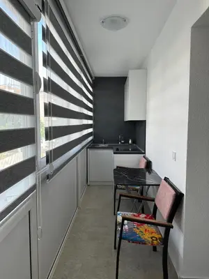a small kitchen with a table and a chair at D&D I apartments in Sutomore