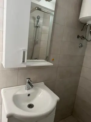a bathroom with a white sink and a mirror at D&D I apartments in Sutomore