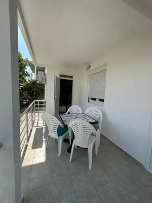 a patio with a table and chairs on a balcony at D&D I apartments in Sutomore