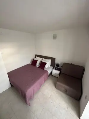 a bedroom with a large bed and a chair at D&D I apartments in Sutomore