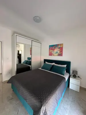 a bedroom with a large bed and a mirror at D&D I apartments in Sutomore