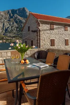 a table with a vase of flowers on a balcony at M&M Bay Haven in Kotor