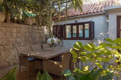 a wooden table and chairs in a yard at M&M Bay Haven in Kotor