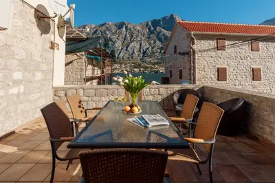 a table and chairs on a balcony with a view at M&M Bay Haven in Kotor