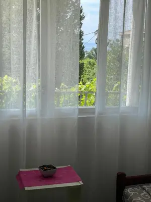 a bowl on a table in front of a window at Apartments Matija in Sutomore