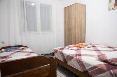 a bedroom with two beds and a wooden cabinet at Apartments Matija in Sutomore
