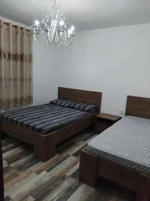 a bedroom with two beds and a chandelier at Apartments Nona in Ulcinj