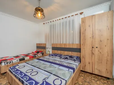 a bedroom with two beds and a chandelier at Apartments Nona in Ulcinj