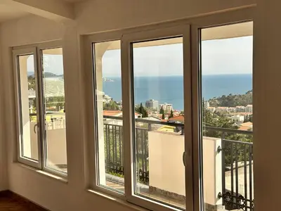 a room with windows with a view of the city at Best View Apartment in Sutomore