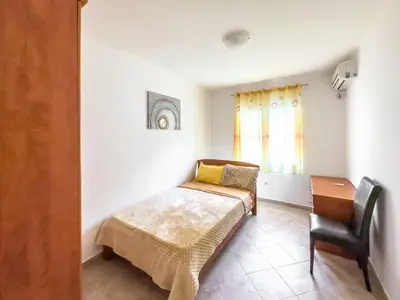 a bedroom with a bed and a desk and a chair at Appartment Frick in Sutomore