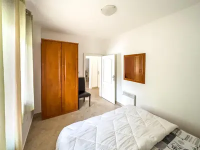 a bedroom with a white bed and a wooden cabinet at Appartment Frick in Sutomore