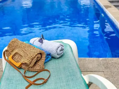 a stuffed teddy bear sitting on a chair next to a pool at Appartment Frick in Sutomore