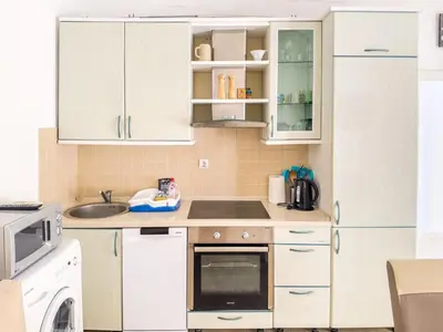 a kitchen with white cabinets and a sink and a dishwasher at Appartment Frick in Sutomore
