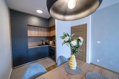 a dining room with a table with a vase of flowers at Apart Kraft in Podgorica