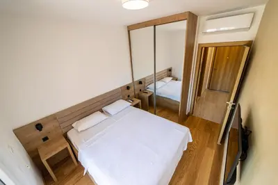 a small room with a bed and a mirror at Apart Kraft in Podgorica