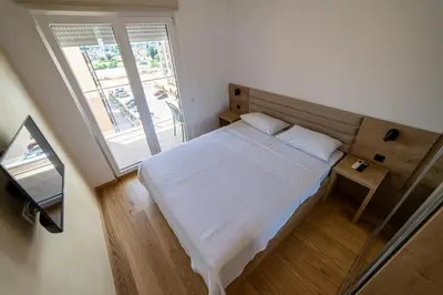 a small bedroom with a bed and a window at Apart Kraft in Podgorica