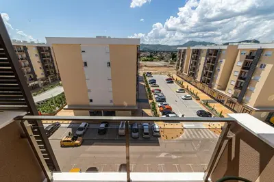 an apartment balcony with a parking lot and buildings at Apart Kraft in Podgorica