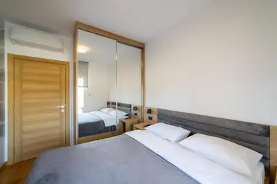 a bedroom with two beds and a large mirror at Apart Kraft in Podgorica