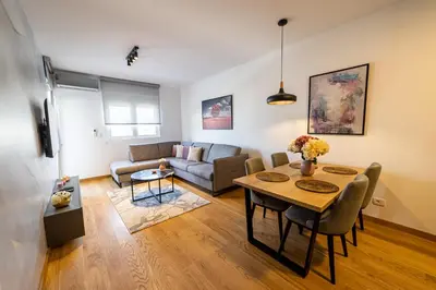 a living room with a table and a couch at Apart Kraft in Podgorica
