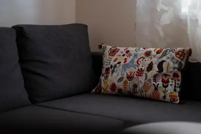 a gray couch with a pillow on it at Apartment Xenia in Petrovac na Moru