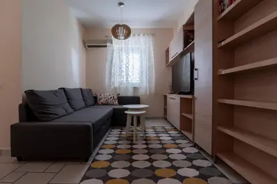 a living room with a couch and a tv at Apartment Xenia in Petrovac na Moru
