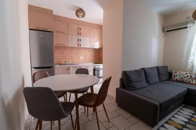 a kitchen and a living room with a table and a couch at Apartment Xenia in Petrovac na Moru