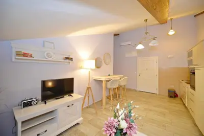 a living room with a tv and a table with chairs at Old Town View - Romantic & Super Stylish in Kotor