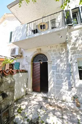 a house with a wooden door and a balcony at Old Town View - Romantic & Super Stylish in Kotor