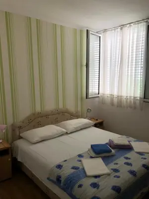 a bedroom with a bed with two towels on it at Ćetković in Petrovac na Moru
