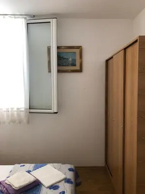 a bedroom with a mirror and a bed and a cabinet at Ćetković in Petrovac na Moru