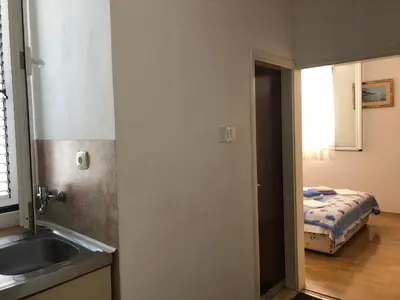 a kitchen with a sink and a bedroom with a bed at Ćetković in Petrovac na Moru