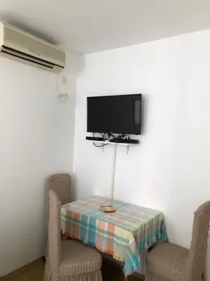 a room with a table with two chairs and a tv at Ćetković in Petrovac na Moru