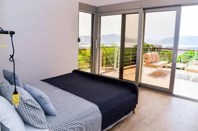 a bedroom with a bed and a balcony at Golden Suit Tivat Heights-Pool & Seaview C1 in Kavač