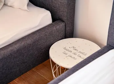 a small table with a sign on it next to a bed at Golden Suit Tivat Heights-Pool & Seaview C1 in Kavač