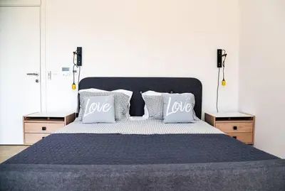 a bedroom with a large bed with two night stands at Golden Suit Tivat Heights-Pool & Seaview C1 in Kavač