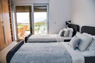 a hotel room with two beds and a balcony at Golden Suit Tivat Heights-Pool & Seaview C1 in Kavač