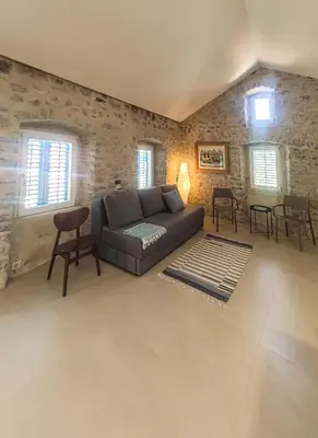 a living room with a couch and a table and chairs at Skalina House in Tivat