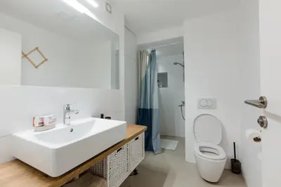 a white bathroom with a sink and a toilet at Skalina House in Tivat