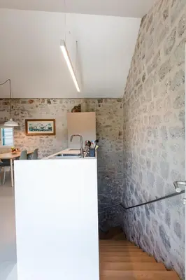 a kitchen with a stone wall and a sink at Skalina House in Tivat