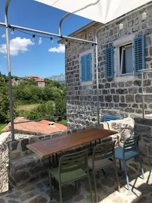 a table and chairs on the patio of a house at Skalina House in Tivat