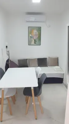 a room with a table and chairs and a bed at Apartmani Ema in Sutomore