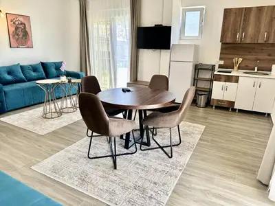 a kitchen and living room with a table and chairs at Akhdar Apartments in Utjeha