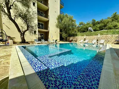 a swimming pool with blue tiles in a building at Akhdar Apartments in Utjeha