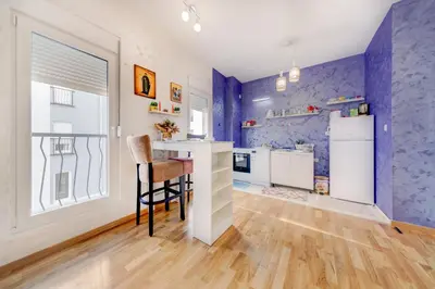 a kitchen with purple walls and a table and chairs at Plum Apartment in Podgorica