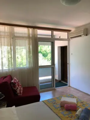 a living room with a couch and a large window at Ćetković 1 in Petrovac na Moru