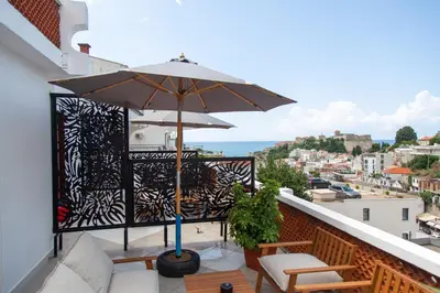 a balcony with a table and an umbrella at Apartments Milla in Ulcinj