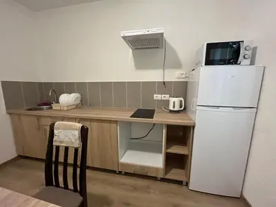 a small kitchen with a white refrigerator and a table at SeaAdrik in Bar