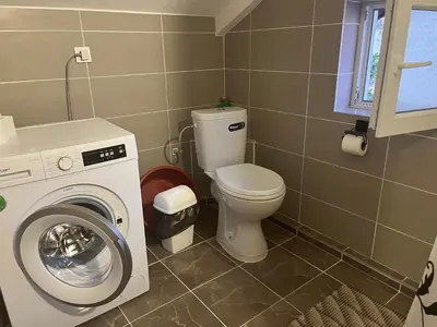 a bathroom with a toilet and a washing machine at SeaAdrik in Bar
