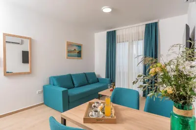 a living room with a blue couch and a table at Apartments Bonazza in Petrovac na Moru